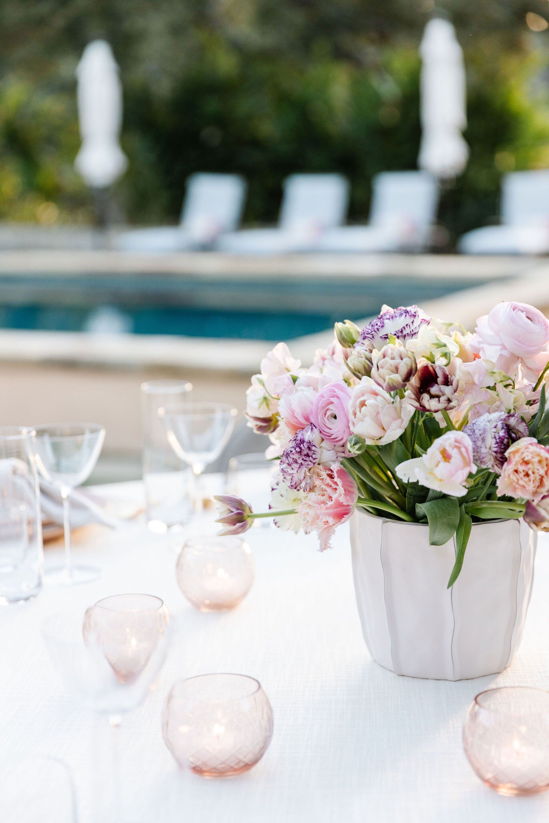 A table with a vase of flowers and candles on it.