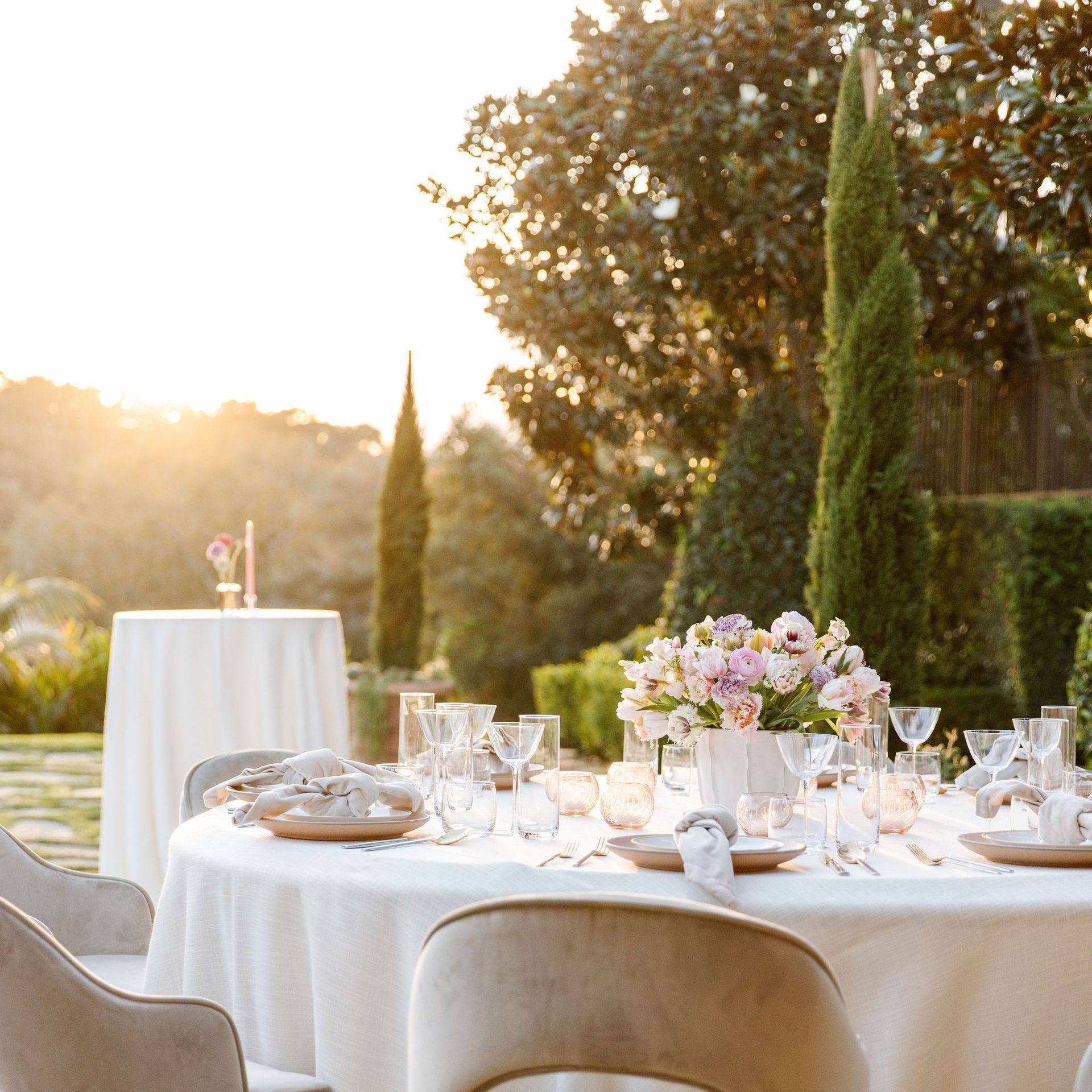 A table set for a wedding reception with a vase of flowers on it
