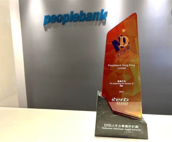 A trophy is sitting on a table in front of a peoplebank sign.