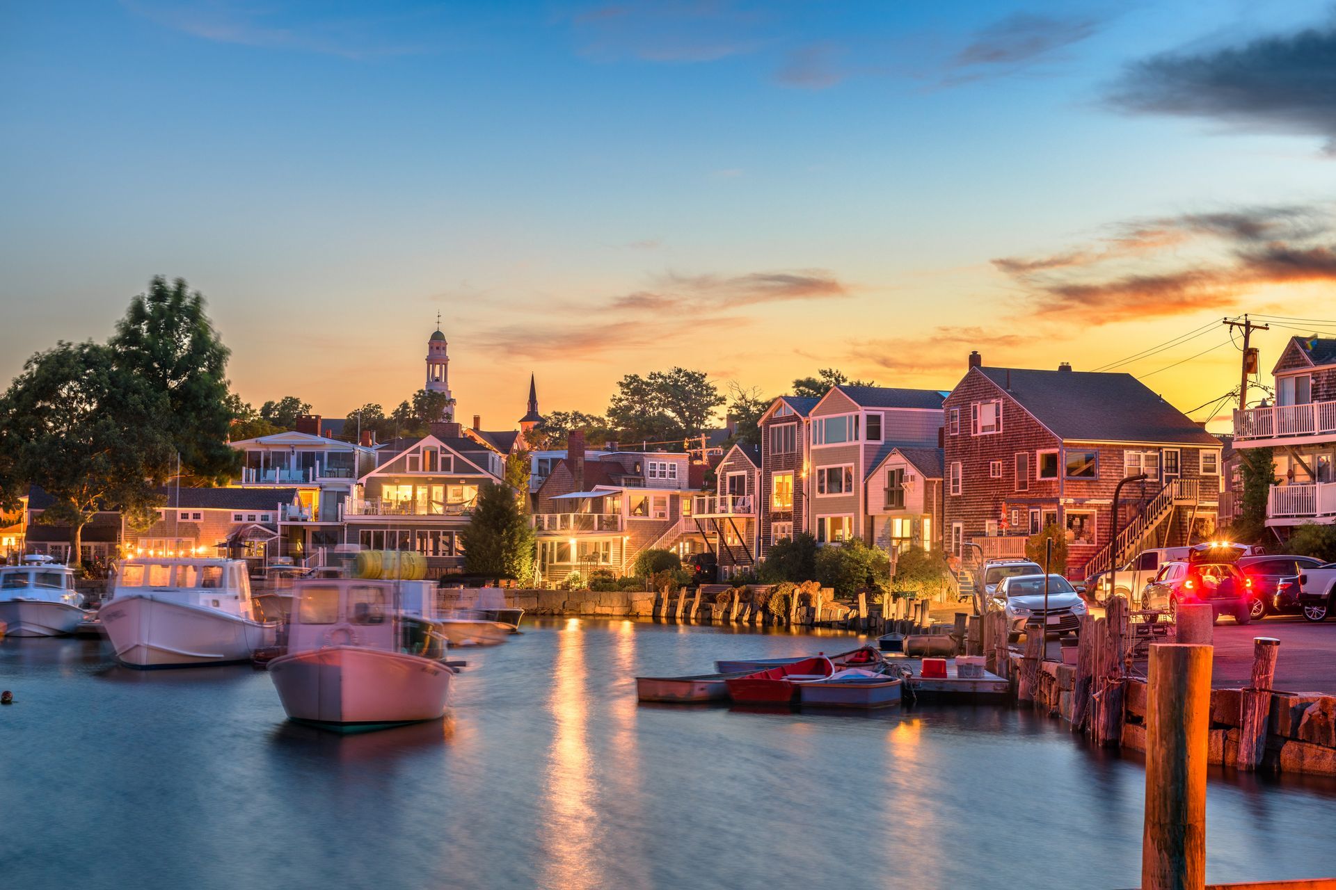 A group of boats are docked in a harbor at sunset.