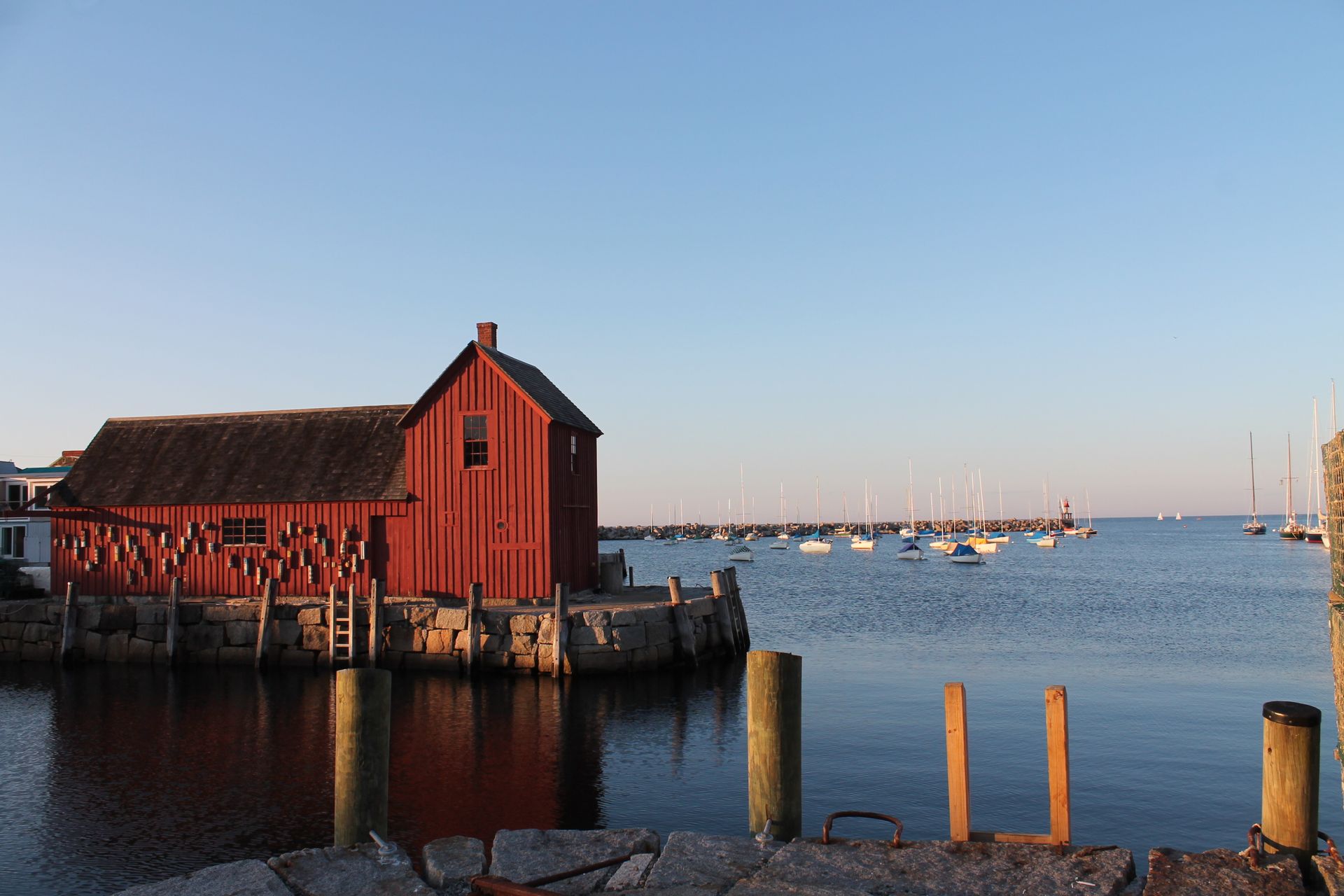 A red barn sits in the middle of a body of water