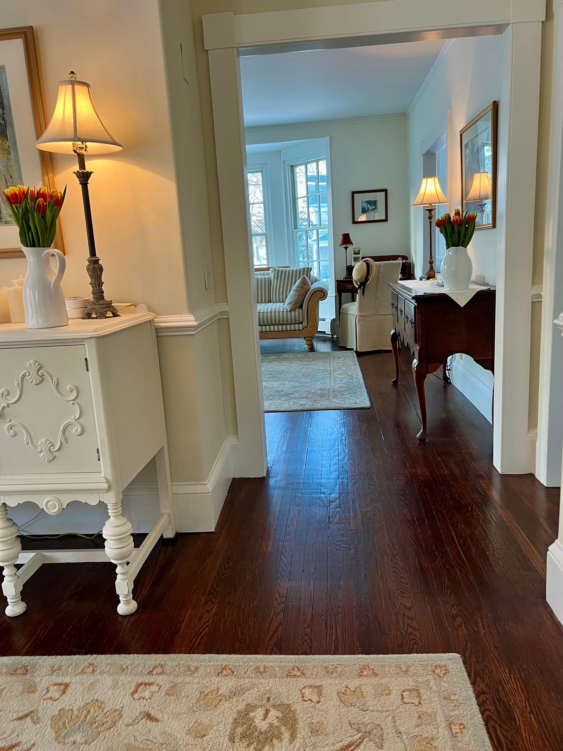 A hallway with hardwood floors leading to a living room