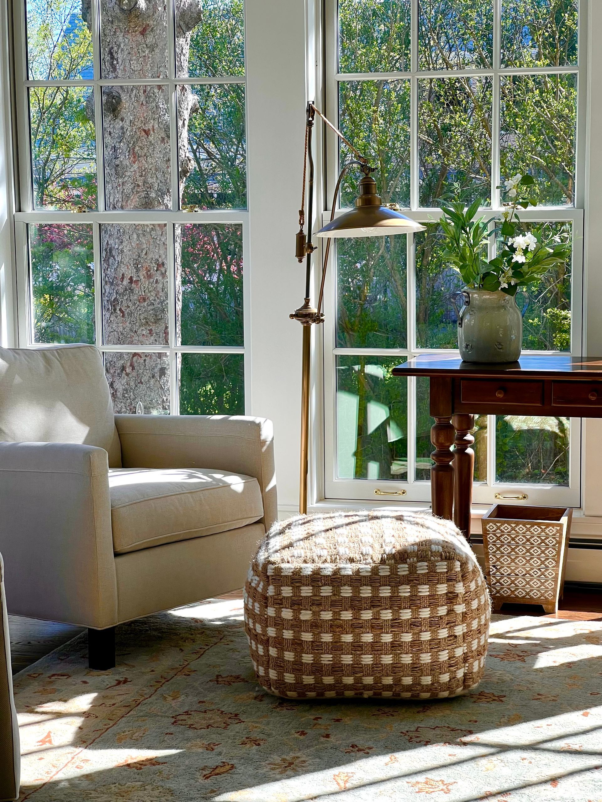 A living room with a chair and ottoman in front of a window