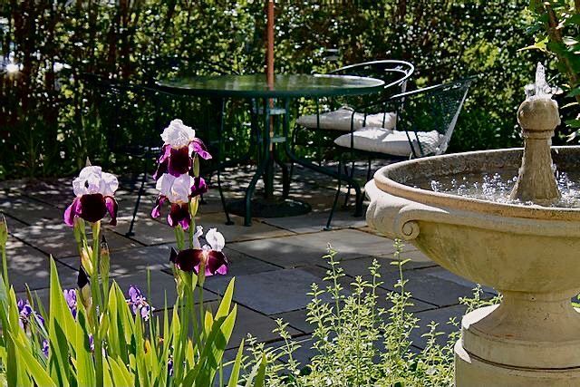 A patio with a table and chairs and a fountain