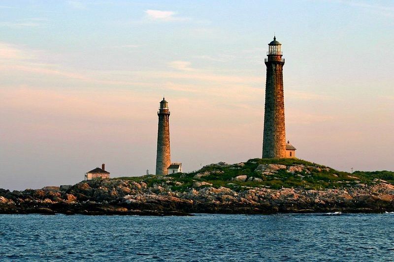 Two lighthouses on a small island in the middle of the ocean.