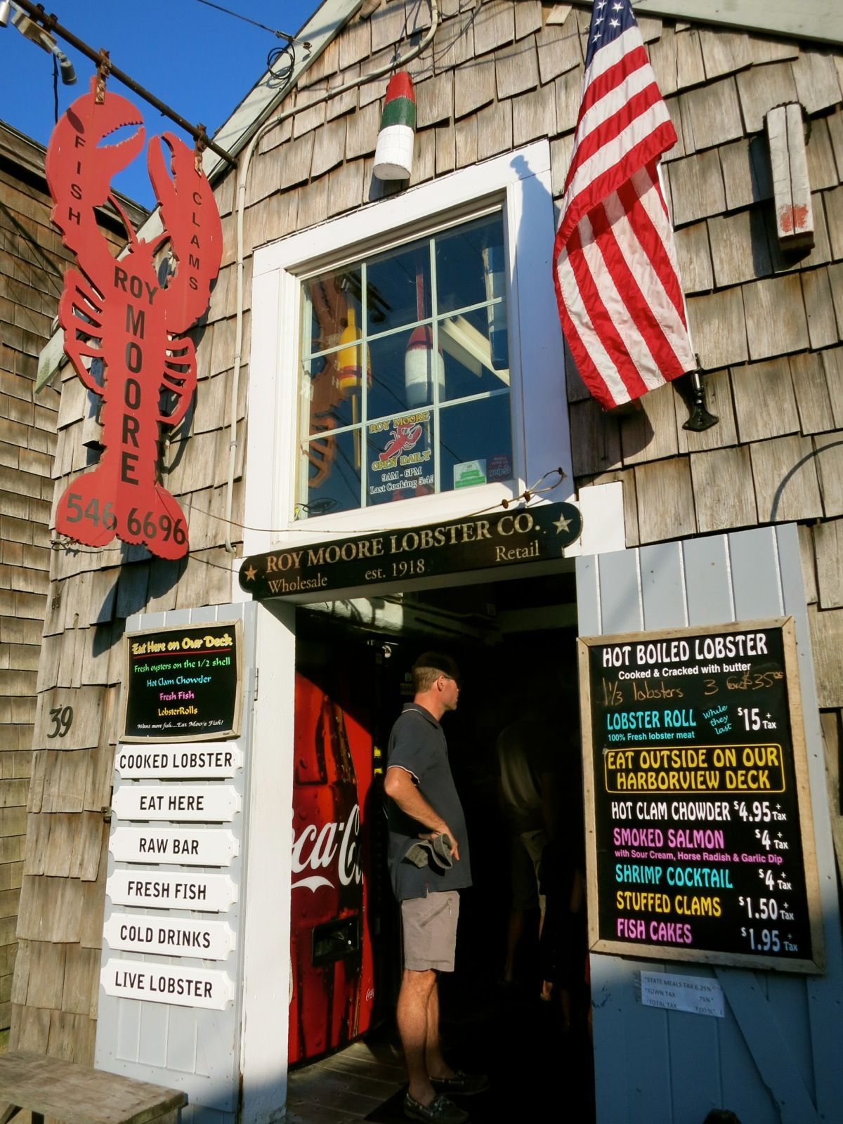 A man standing in front of a lobster restaurant