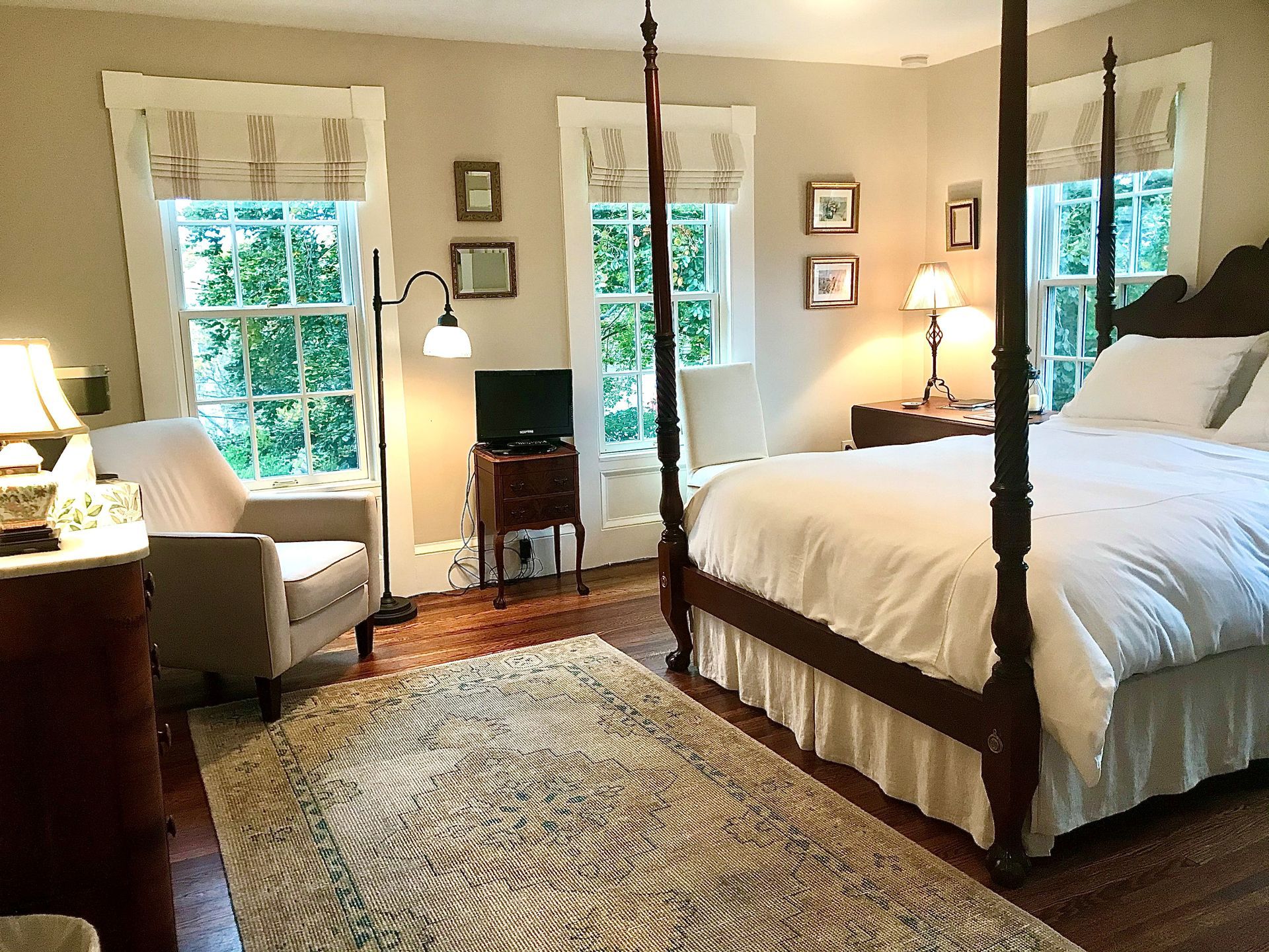 A bedroom with a four poster bed and a chair