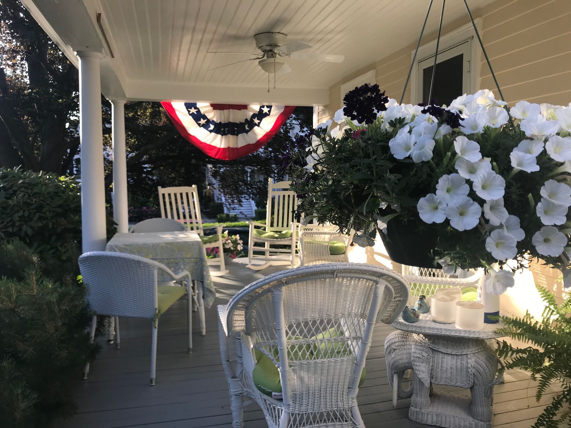 A porch with wicker furniture and flowers on it