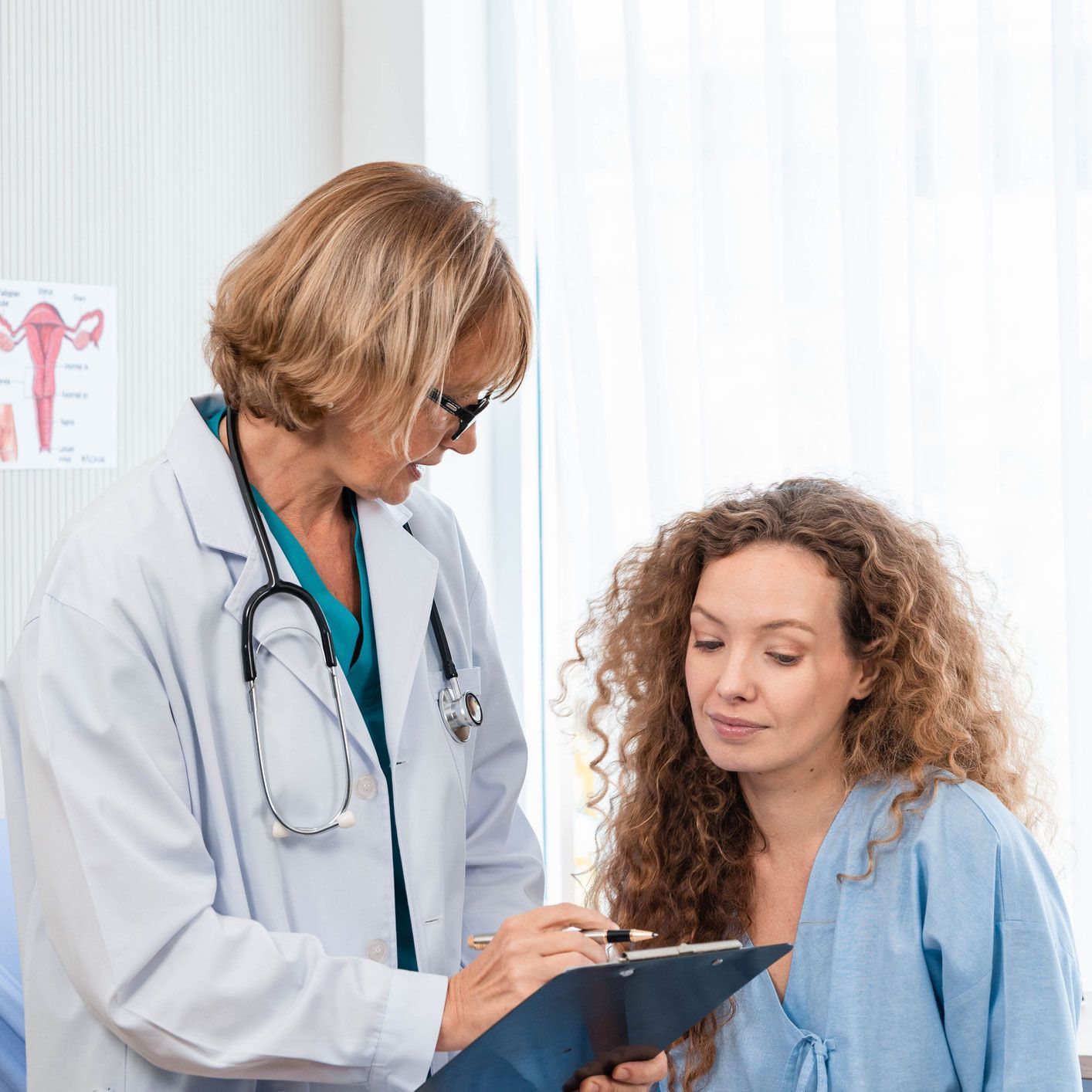 a doctor is talking to a patient who is looking at a clipboard .