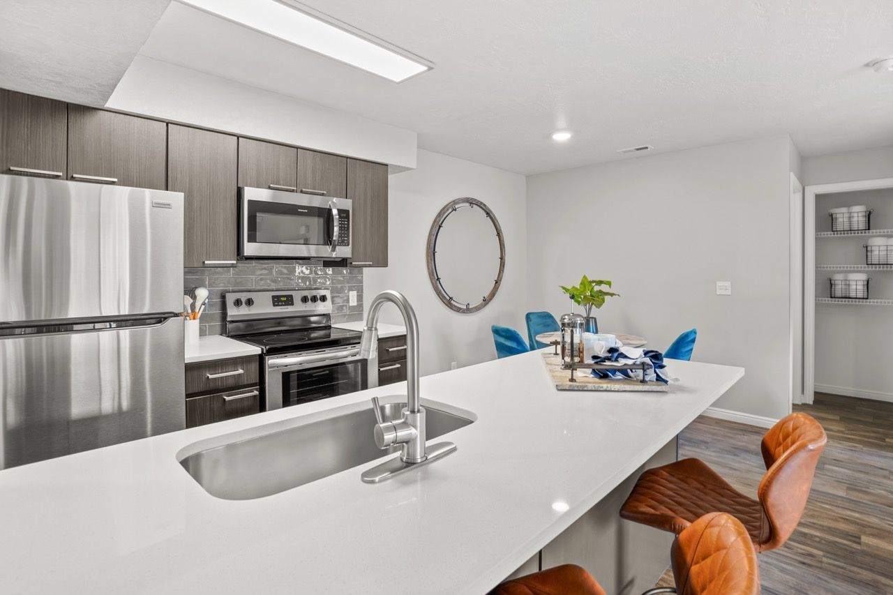 Modern kitchen with stainless steel appliances, large white island, and seating.