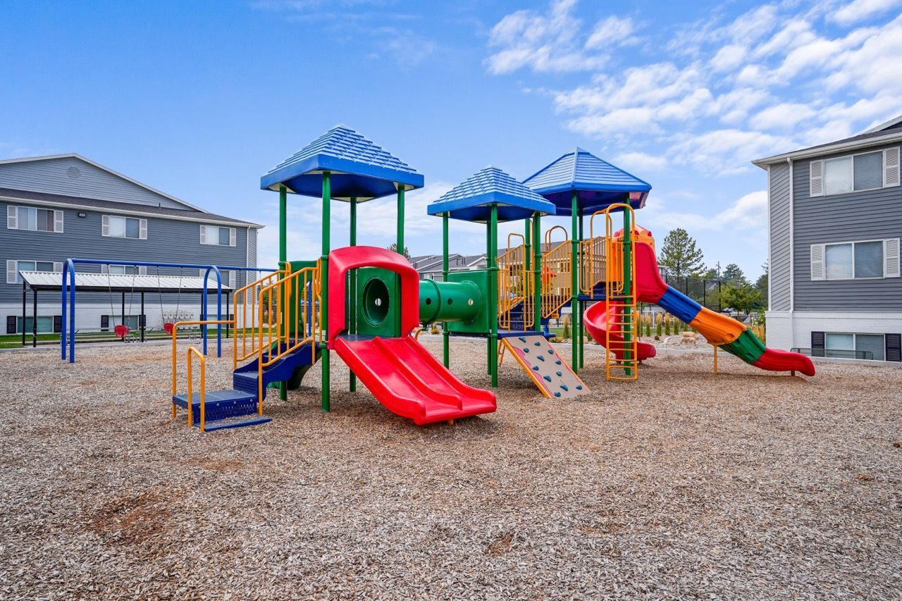 Colorful outdoor playground with slides and climbing structures at an apartment community. Schedule a tour of Turnberry Apartments to explore comfortable pet-friendly apartments in Millcreek, UT, and community amenities.
