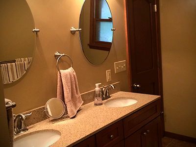 A bathroom with two sinks and two mirrors.