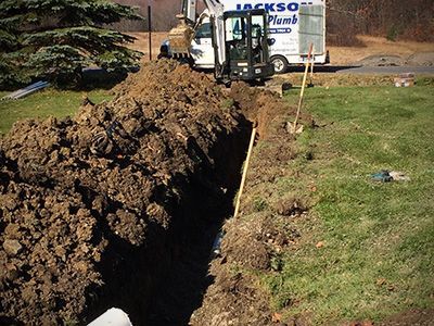 A jackson plumbing truck is digging a hole in the ground