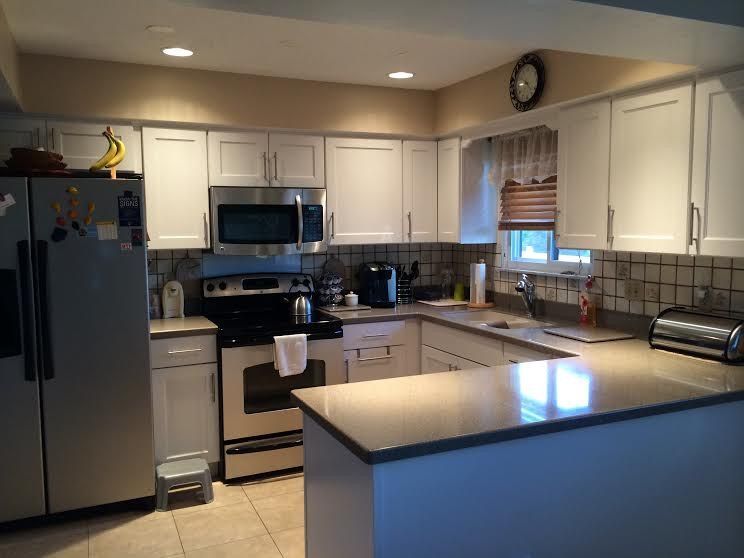 A kitchen with white cabinets and stainless steel appliances