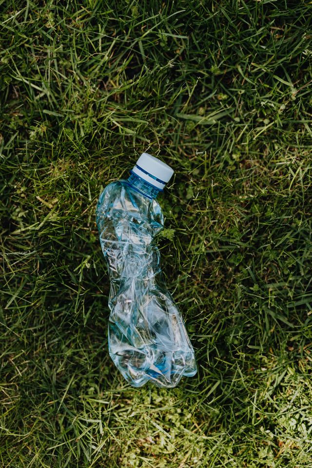 A plastic bottle is laying on the grass.
