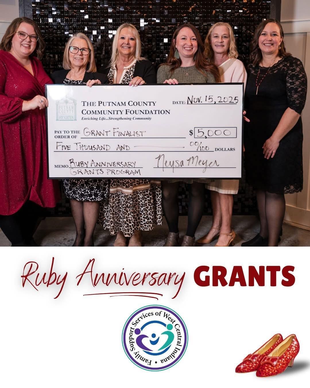 Six women holding a large check, smiling. 