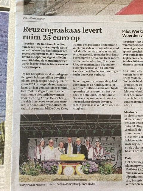Krantenknipsel over een gigantische sprinkhaan. Mensen op een podium poseren bij een weegschaal.