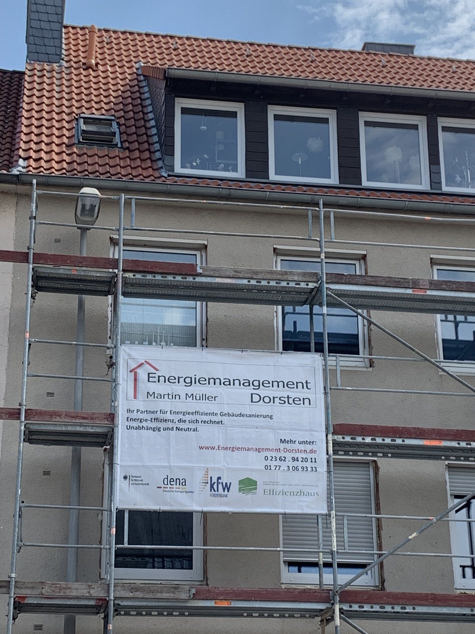 Gebäude mit Gerüst und Banner: Energiemanagement in Dortmund. Bauarbeiten im Gange.