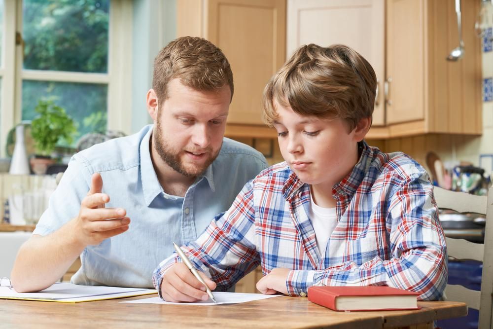 a Man is Helping a Young Boy With His Homework — RIP IT UP Reading in Maitland, NSW