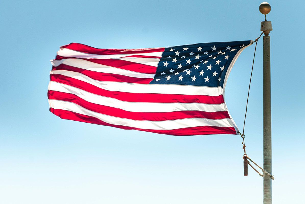 American flag waving in the wind against a clear, blue sky.