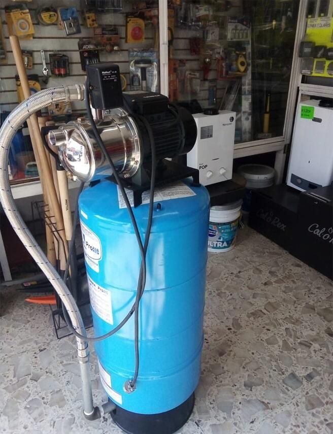 Una bomba de agua está colocada encima de un tanque azul en una tienda.