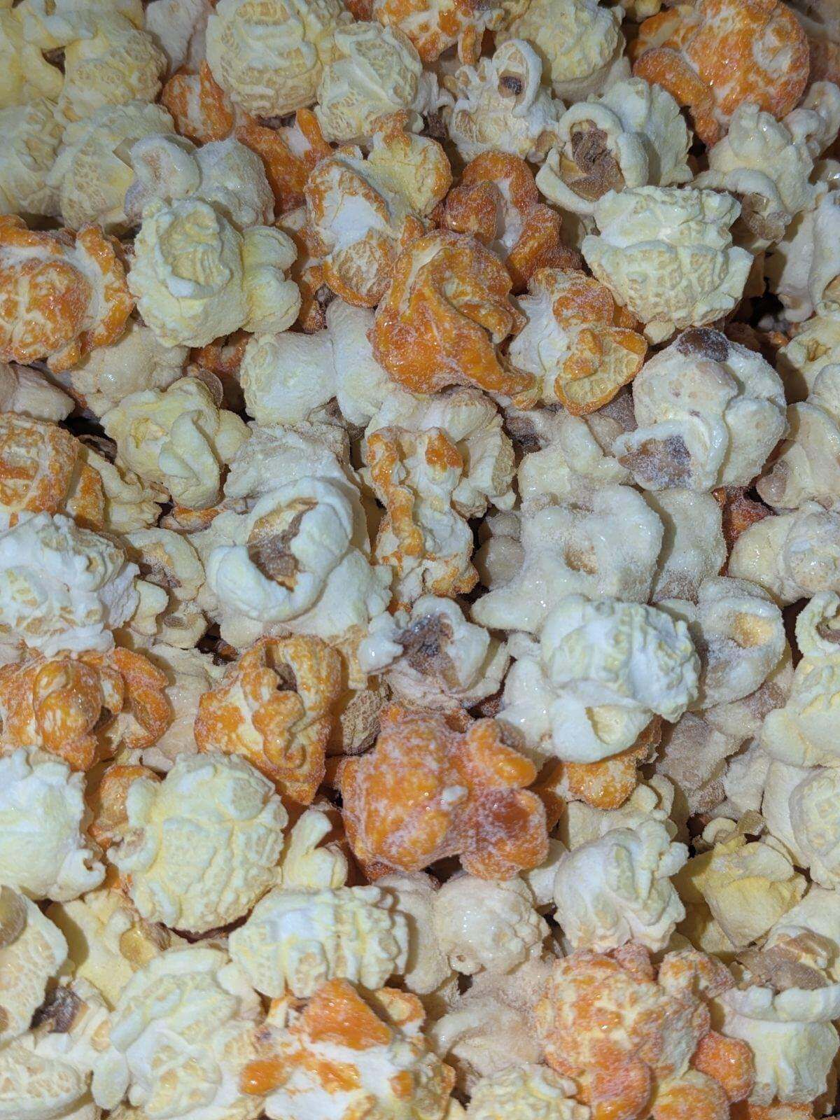 A close up of a pile of popcorn with different flavors.