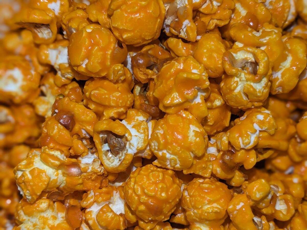 A close up of a pile of caramel popcorn on a table.