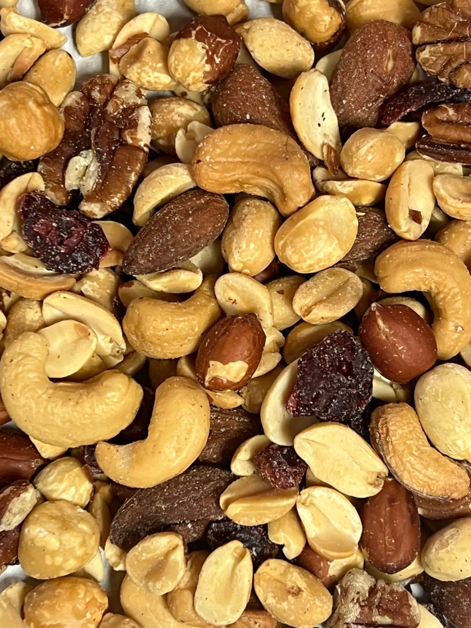 A close up of a pile of nuts and cranberries on a table.