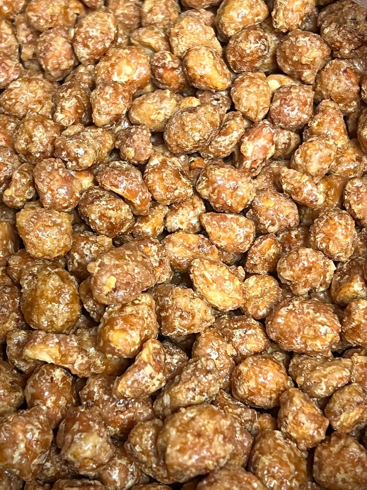 A close up of a pile of caramelized peanuts.