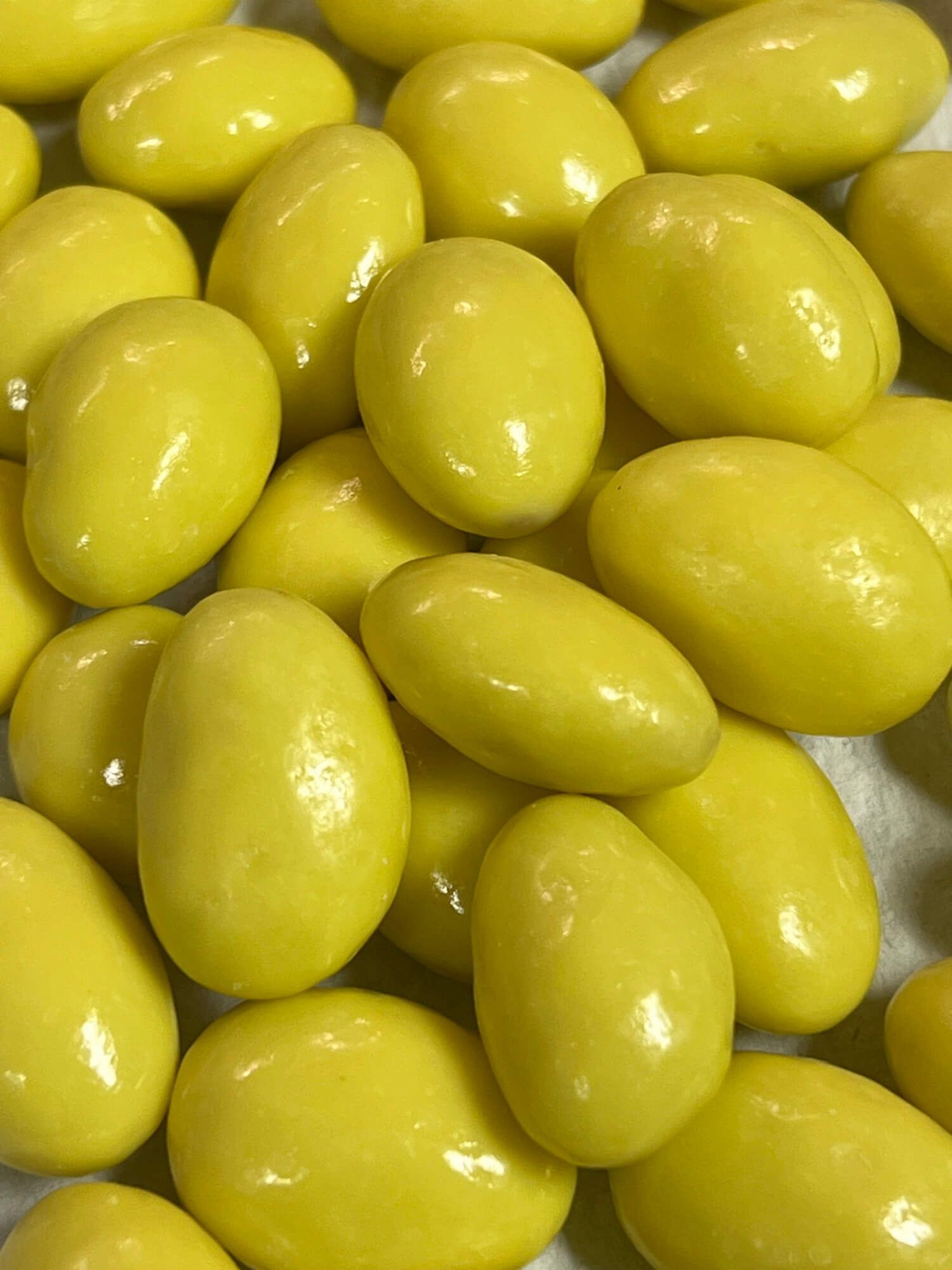 A close up of a pile of yellow almonds on a table.