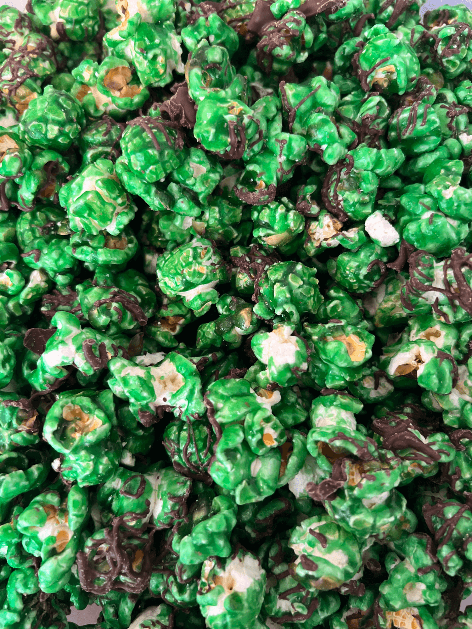 A close up of a pile of green and chocolate popcorn.