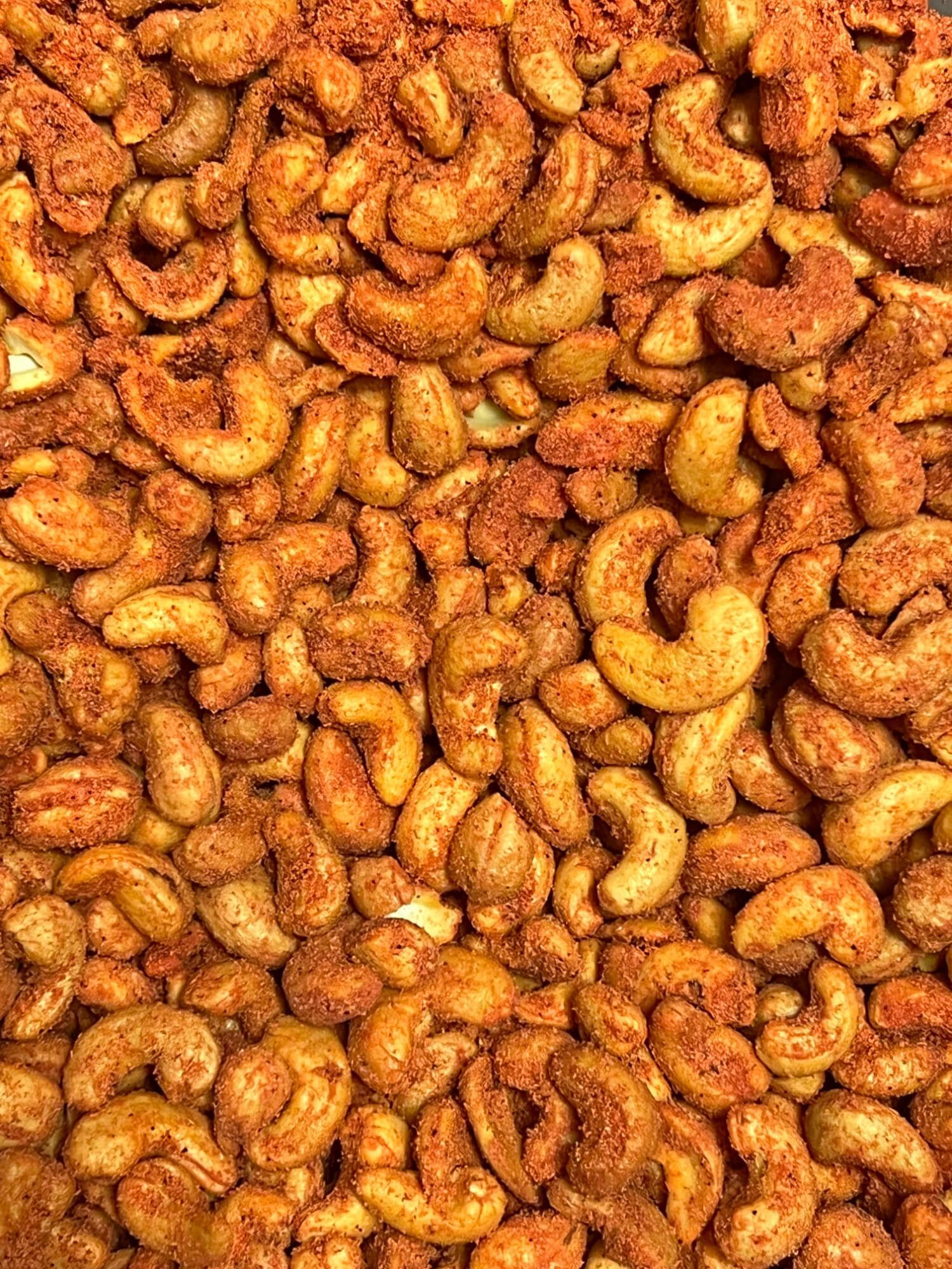 A close up of a pile of roasted cashews on a table.
