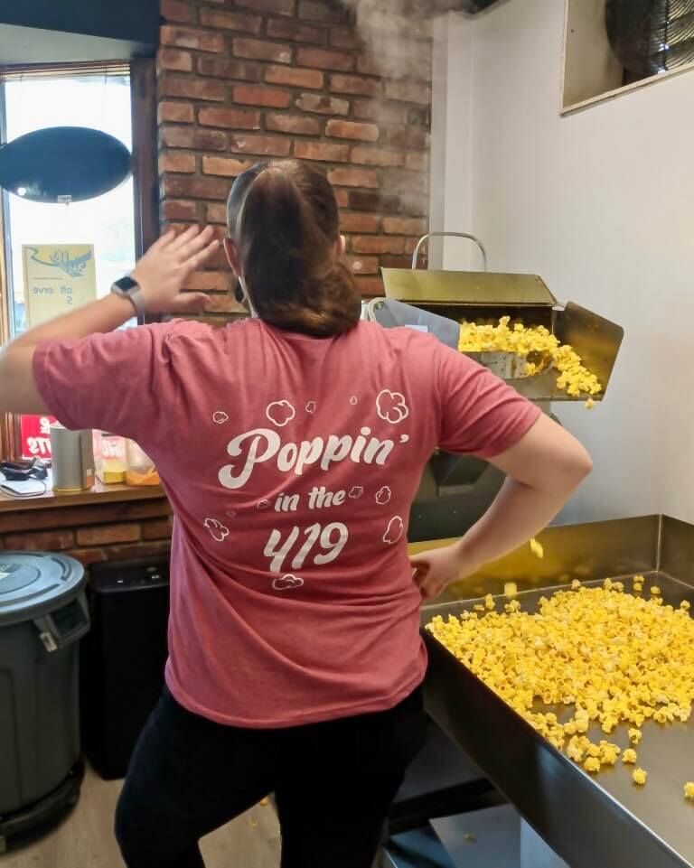 A Great Lakes Popcorn Co - Port Clinton, OH staff member wearing a pink shirt that says 