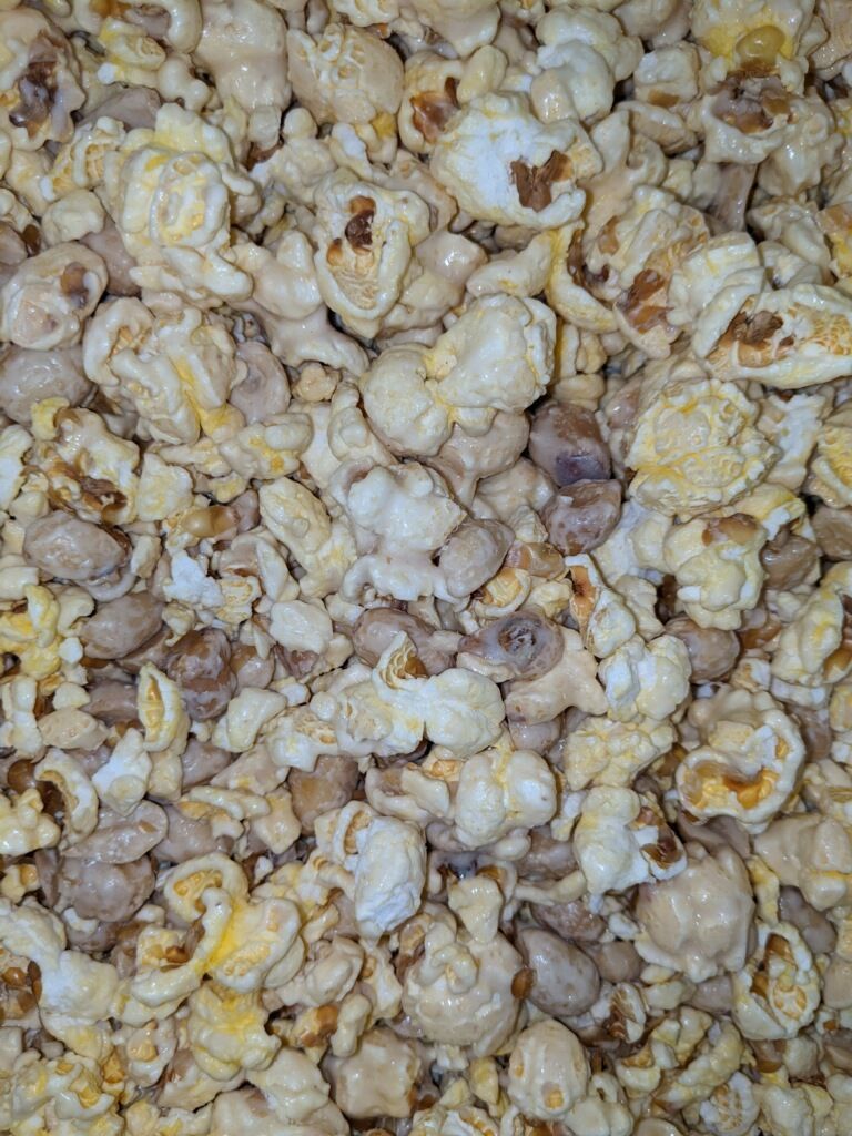 A close up of a pile of popcorn and peanuts.