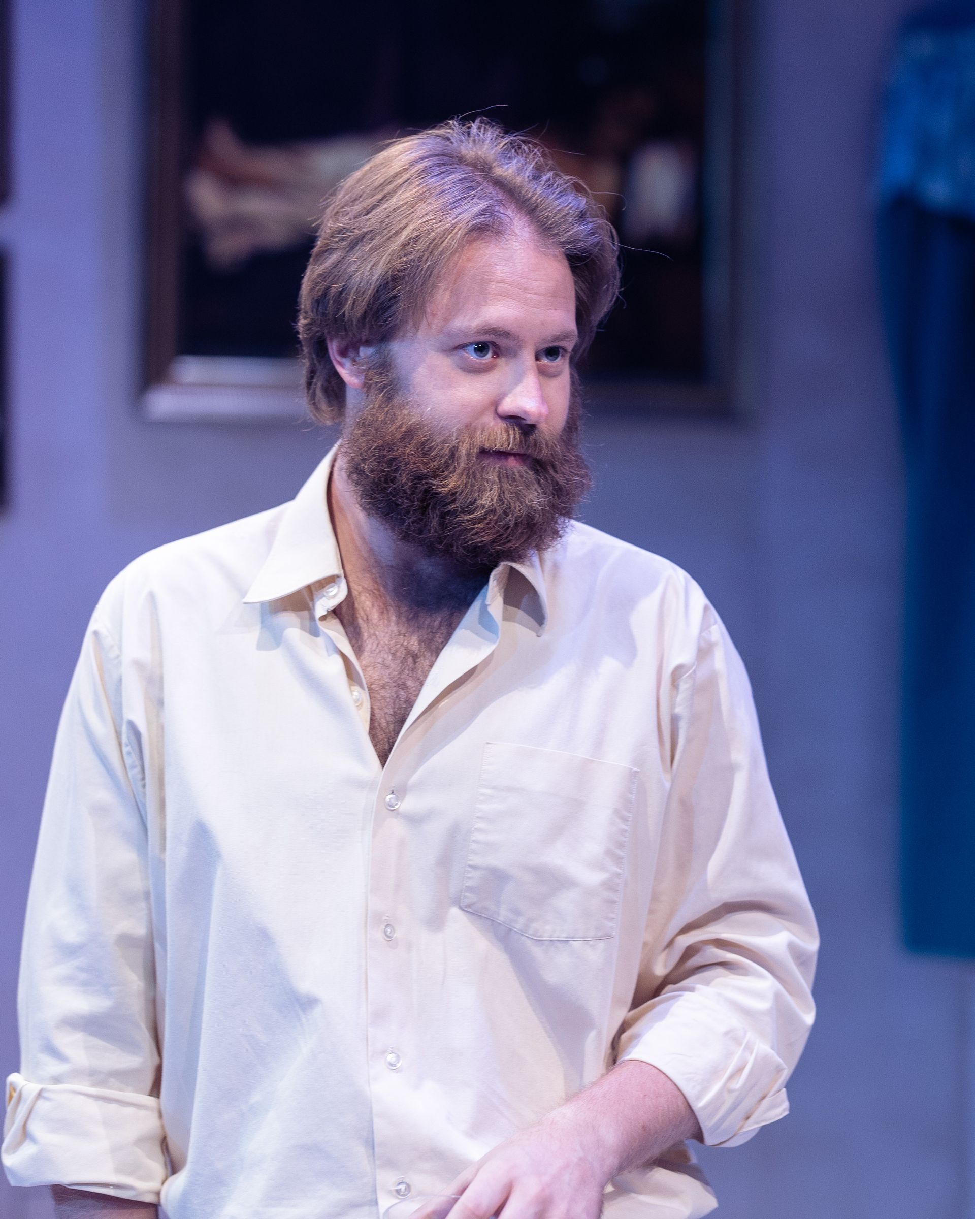 A man with a beard is wearing a white shirt