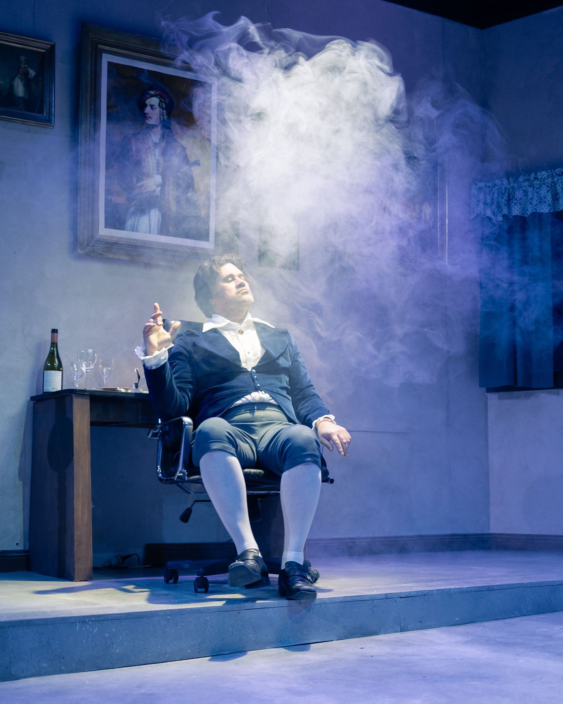 A man is sitting in a chair with smoke coming out of his mouth.