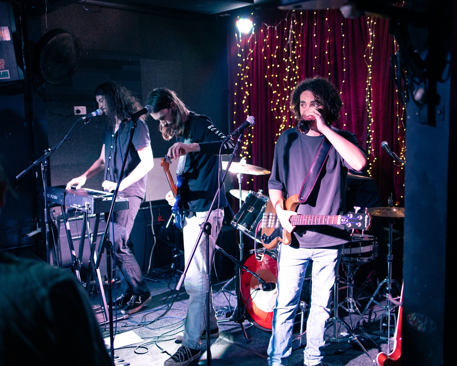 A man playing a guitar in a band on stage