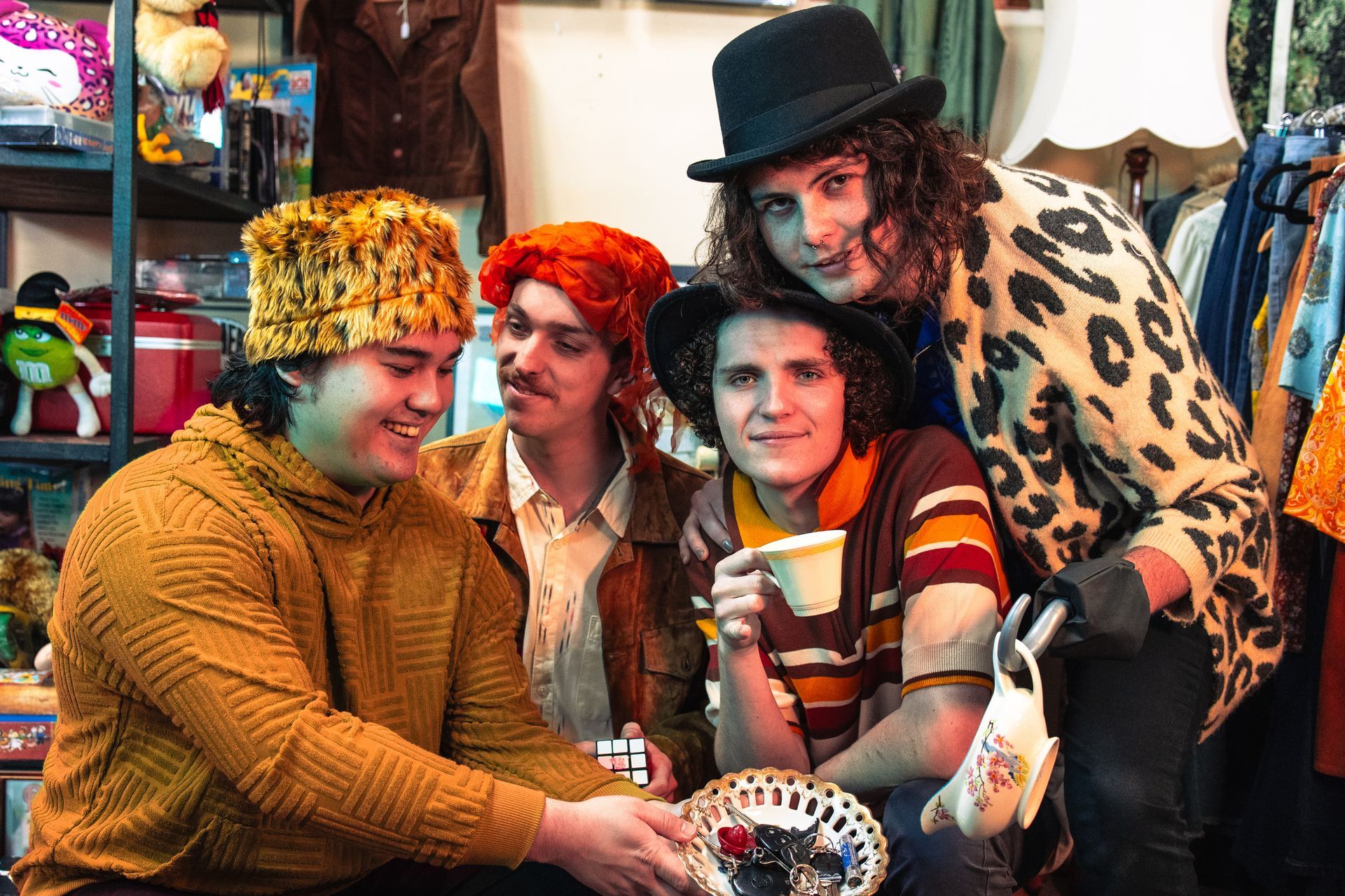 A group of young men are sitting around a table drinking tea.