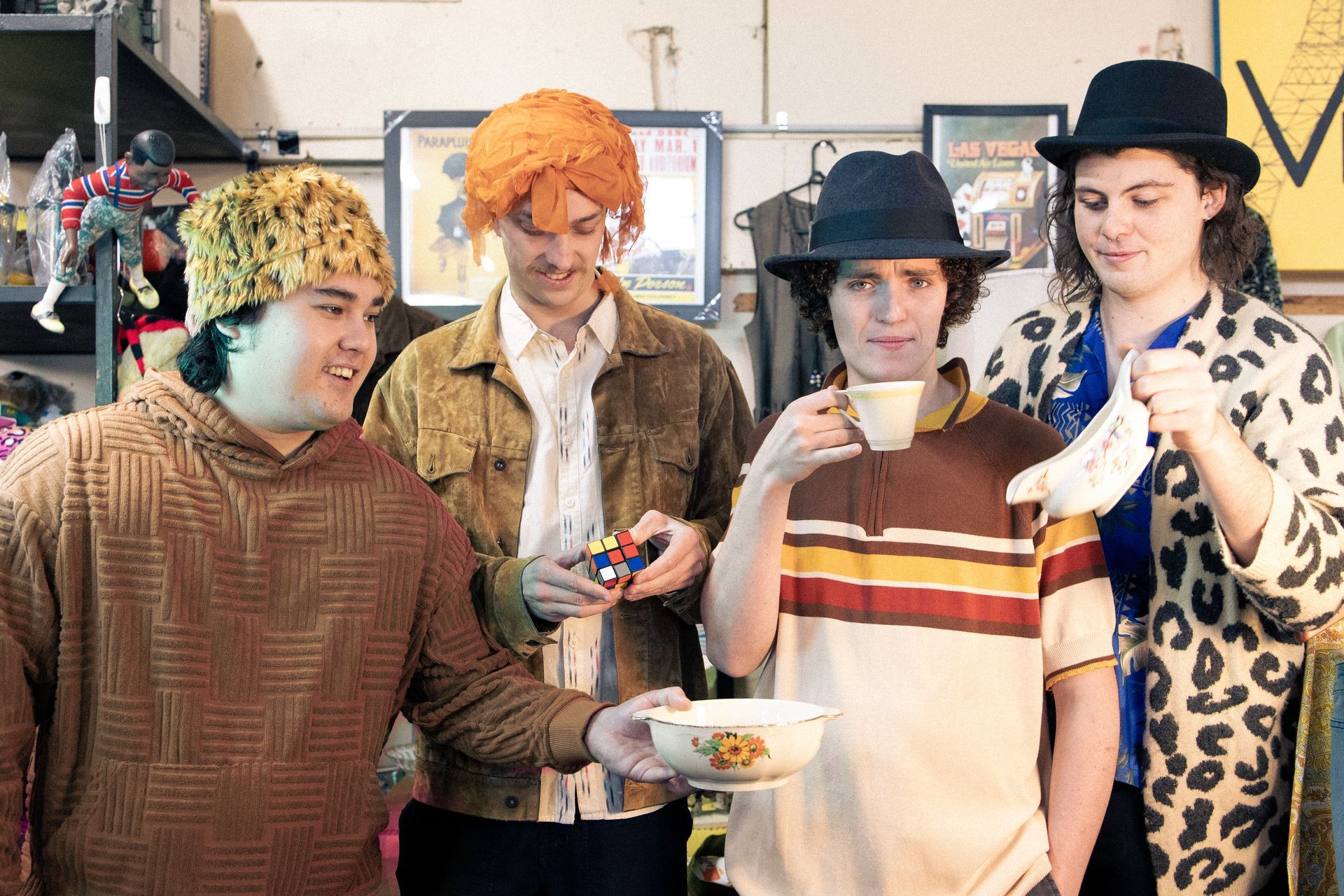 A group of young men are standing next to each other drinking tea.