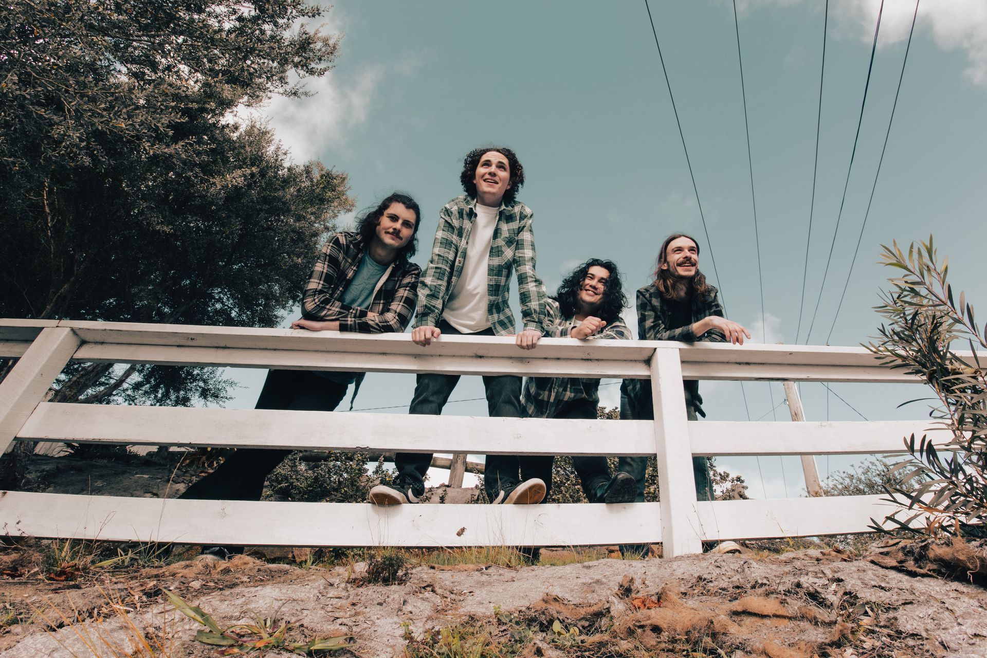 A group of people standing on top of a white fence.
