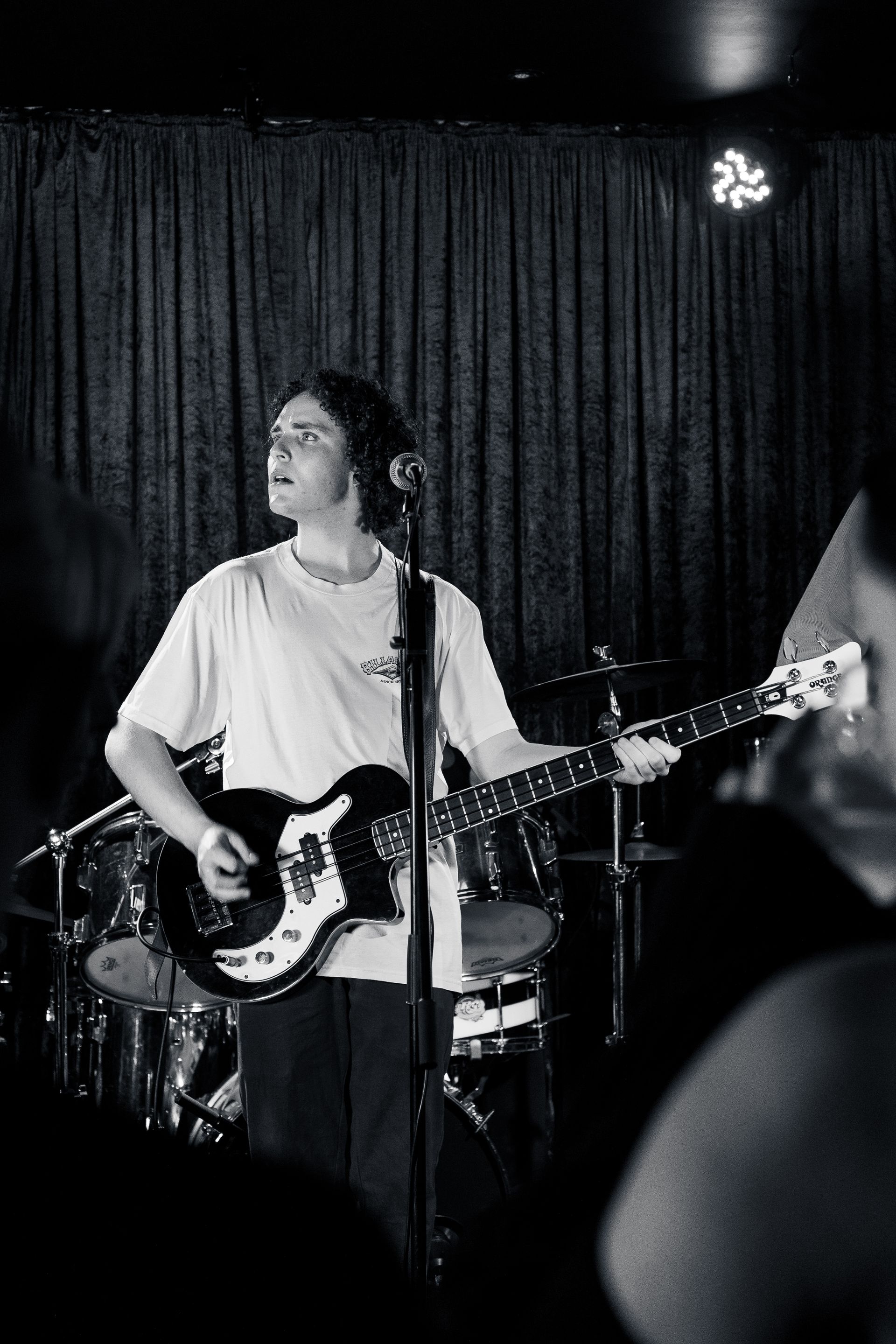 A man is playing a guitar and singing into a microphone on a stage.