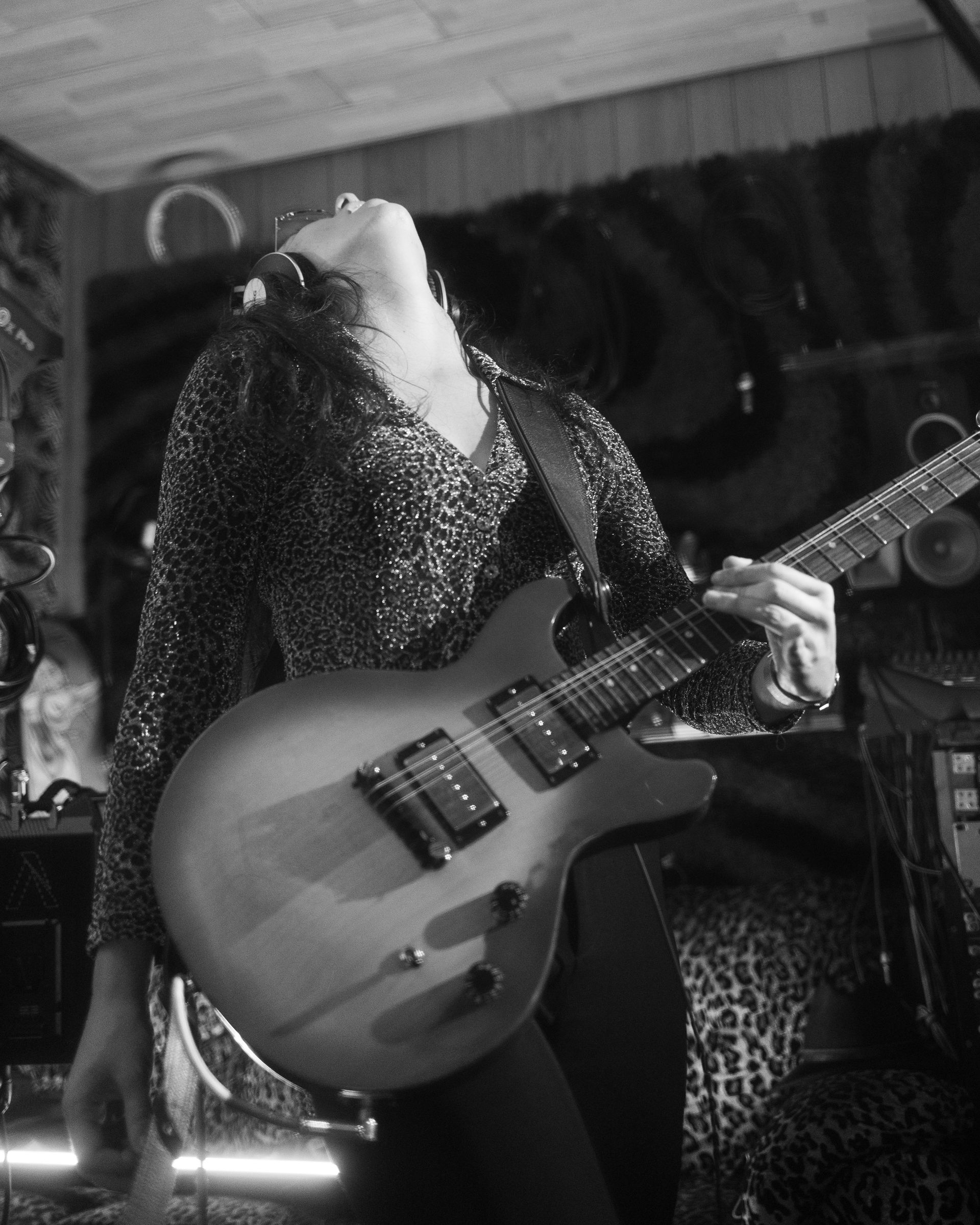 A woman is playing a guitar in a black and white photo
