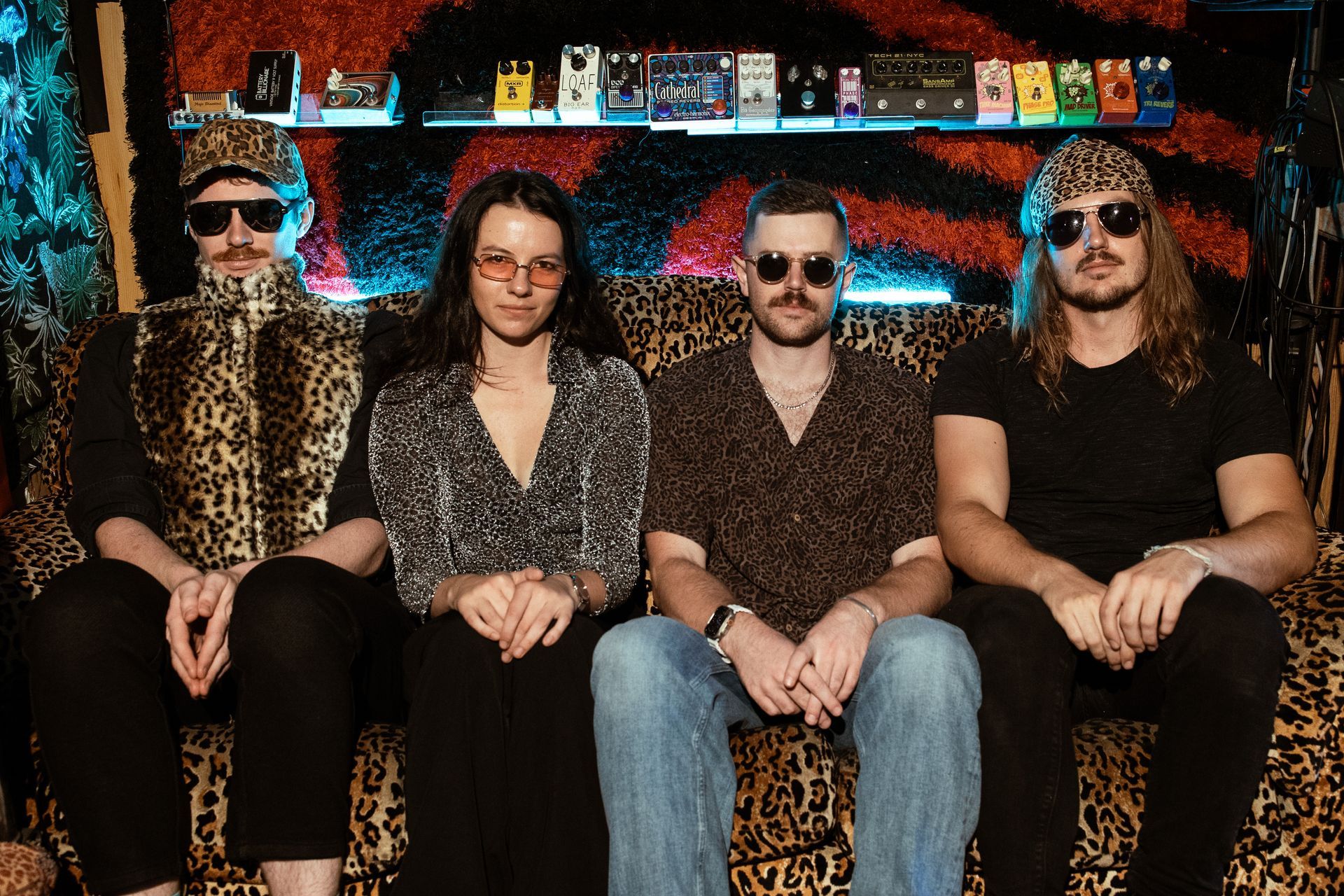 A group of people are sitting on a leopard print couch.