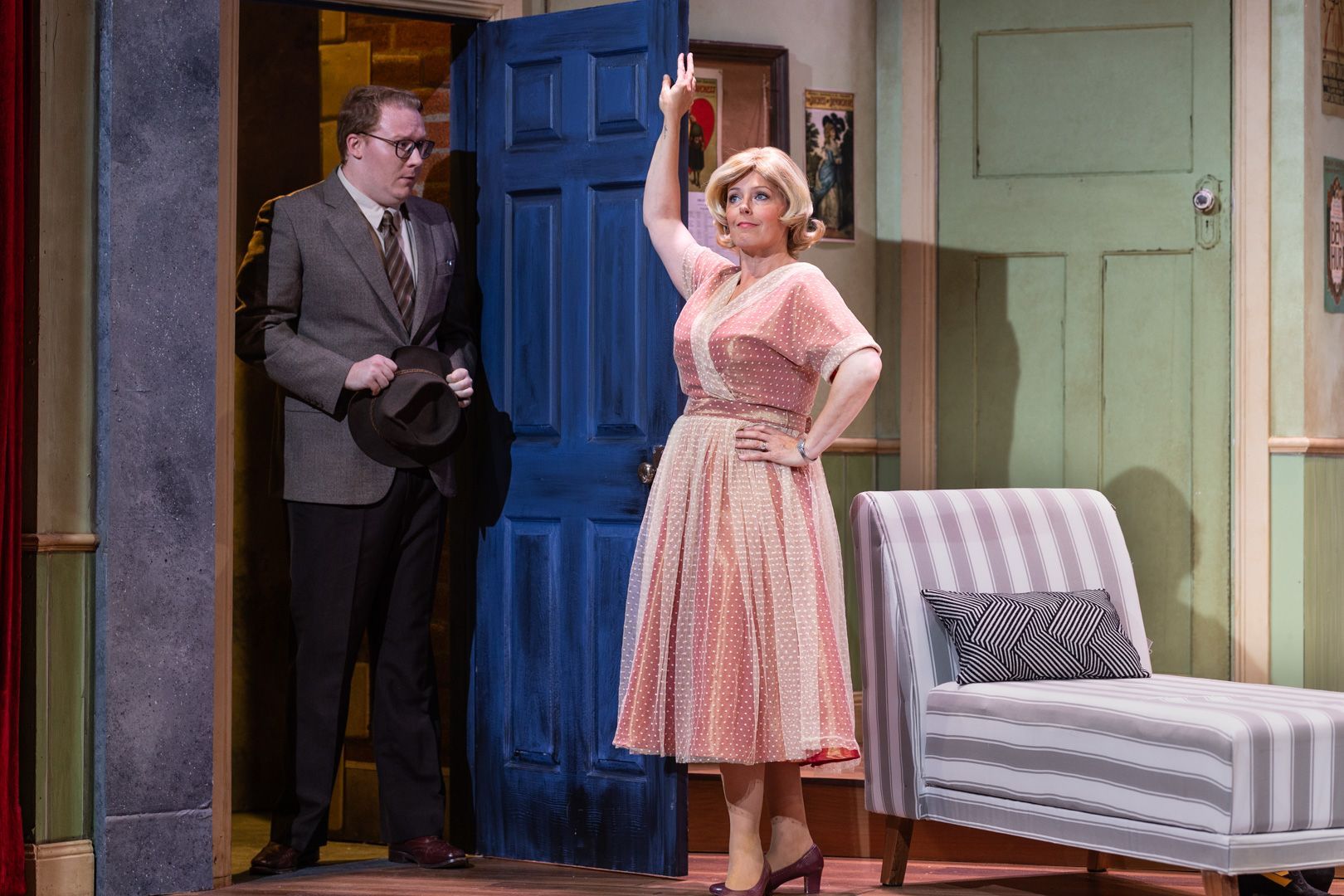A man and a woman are standing in front of a blue door.