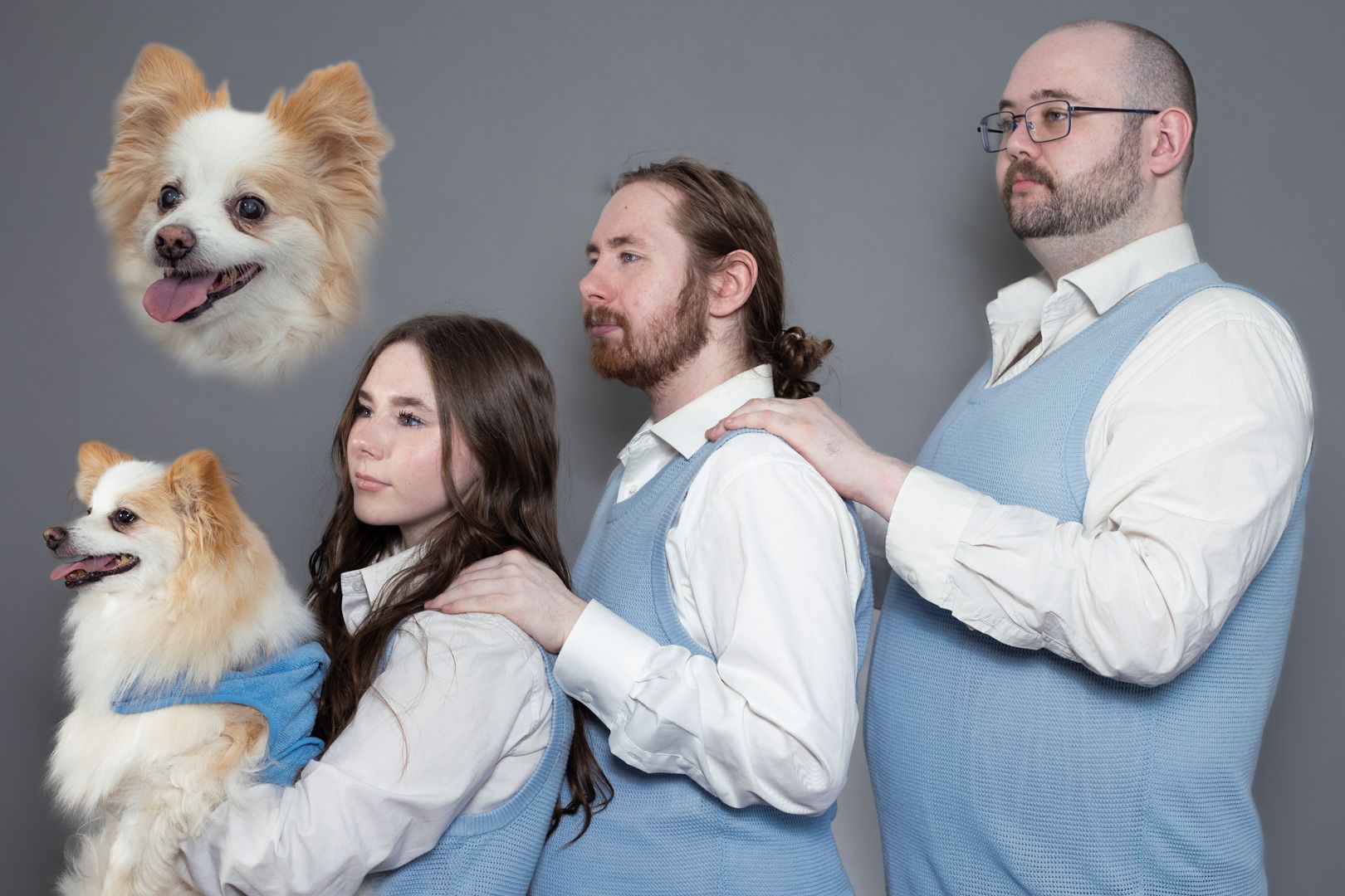 A family is posing for a picture with their dogs.