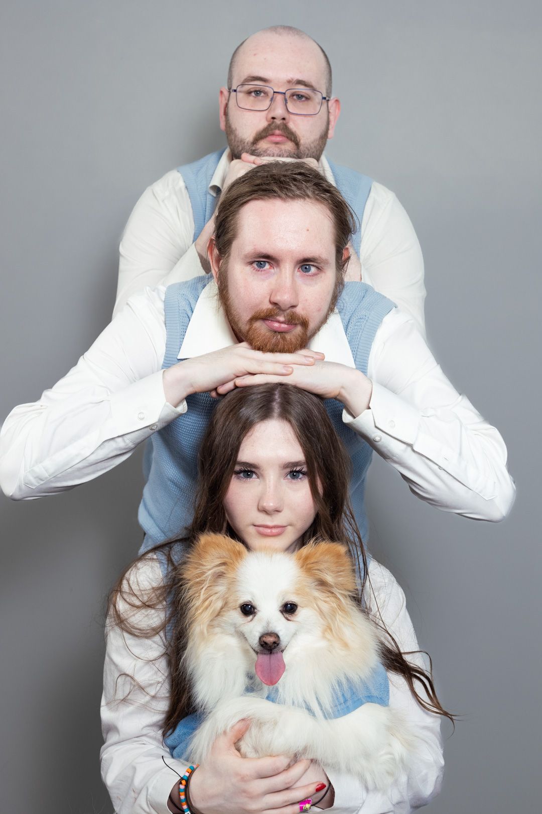 A group of people are posing for a picture with a dog.