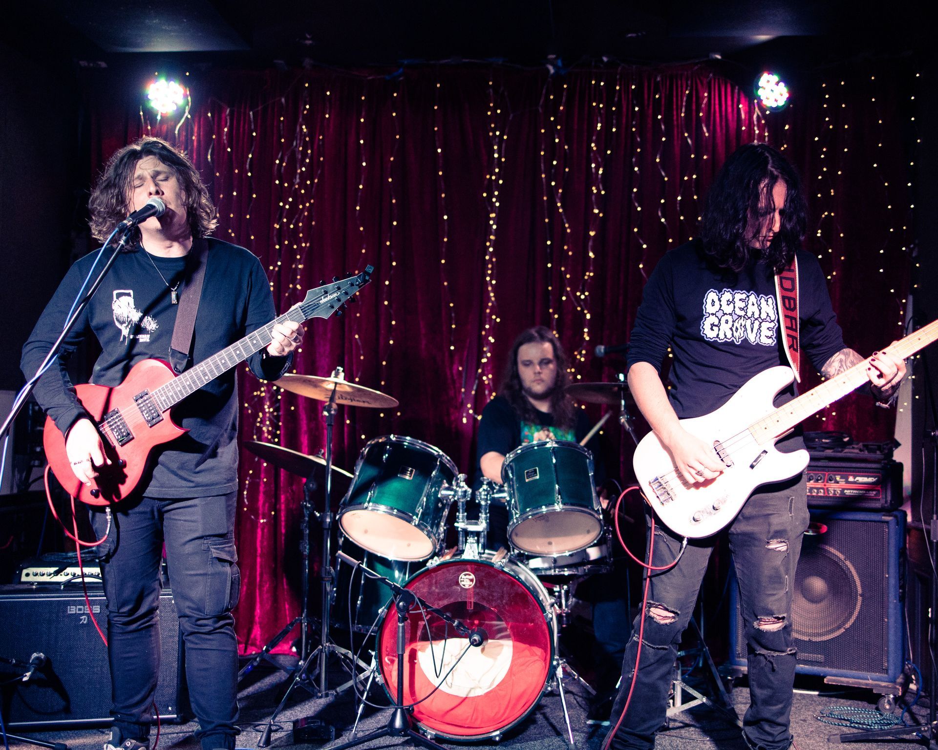 A group of people are playing guitars and drums on a stage.