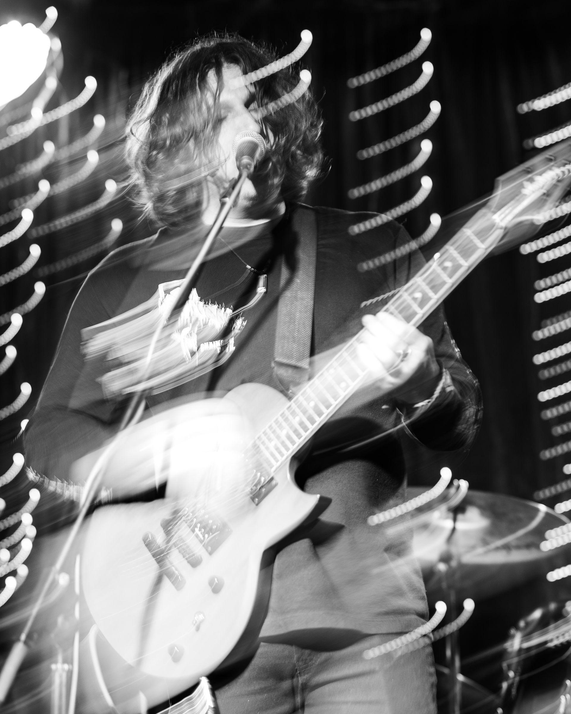 A man is playing a guitar and singing into a microphone