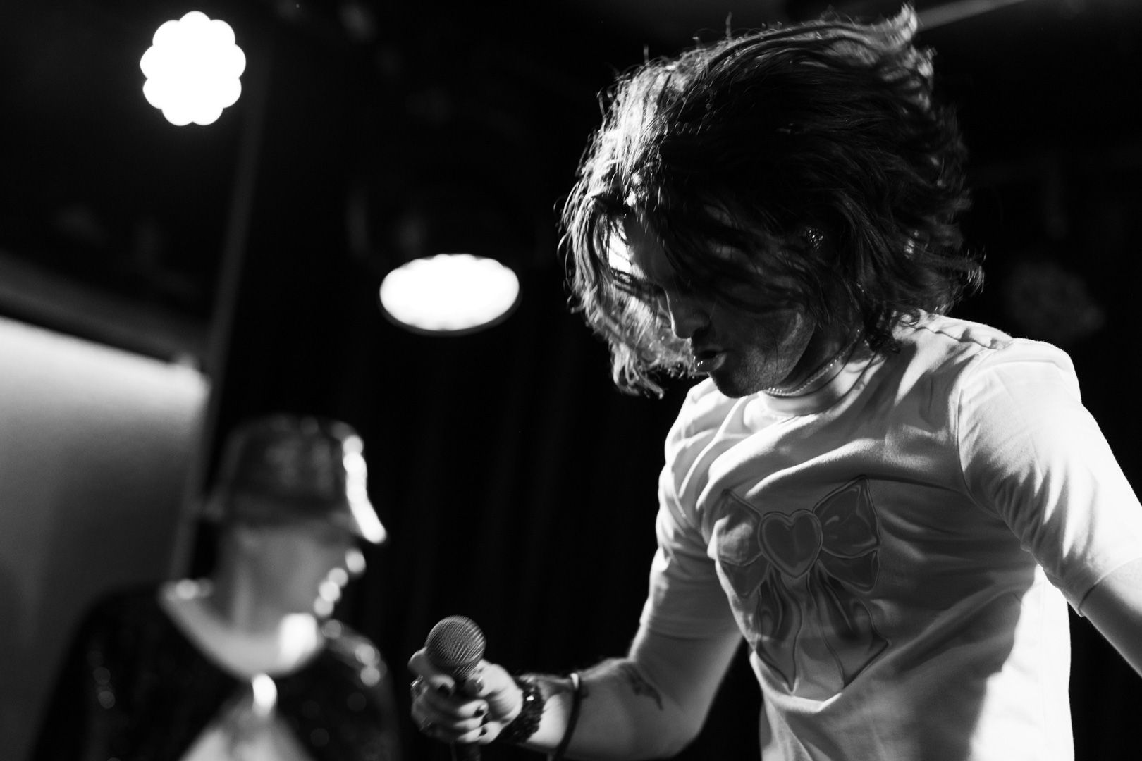 A black and white photo of a man singing into a microphone