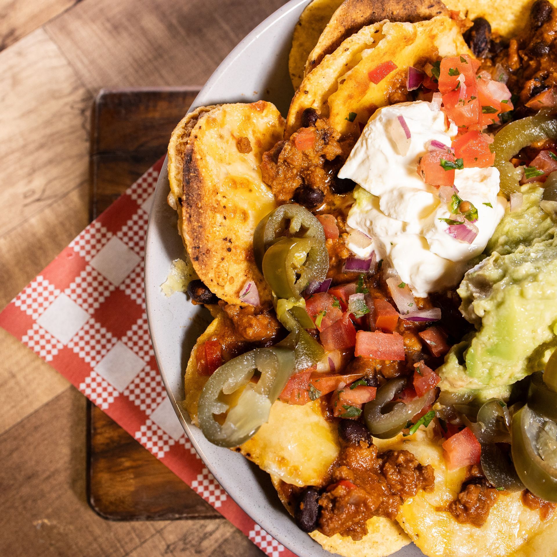A bowl of nachos with guacamole and sour cream